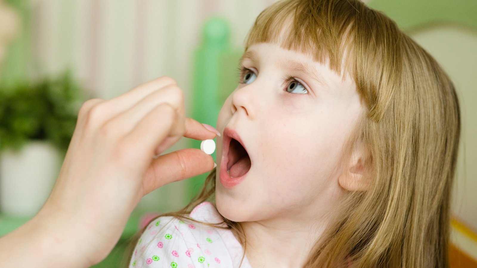 Child receiving pill - closeup