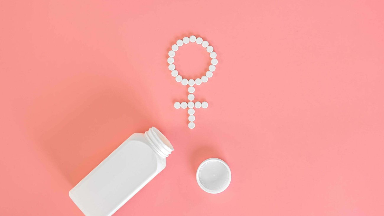 Pills on a pink background, flat lay, women's health, conceptual minimalism.