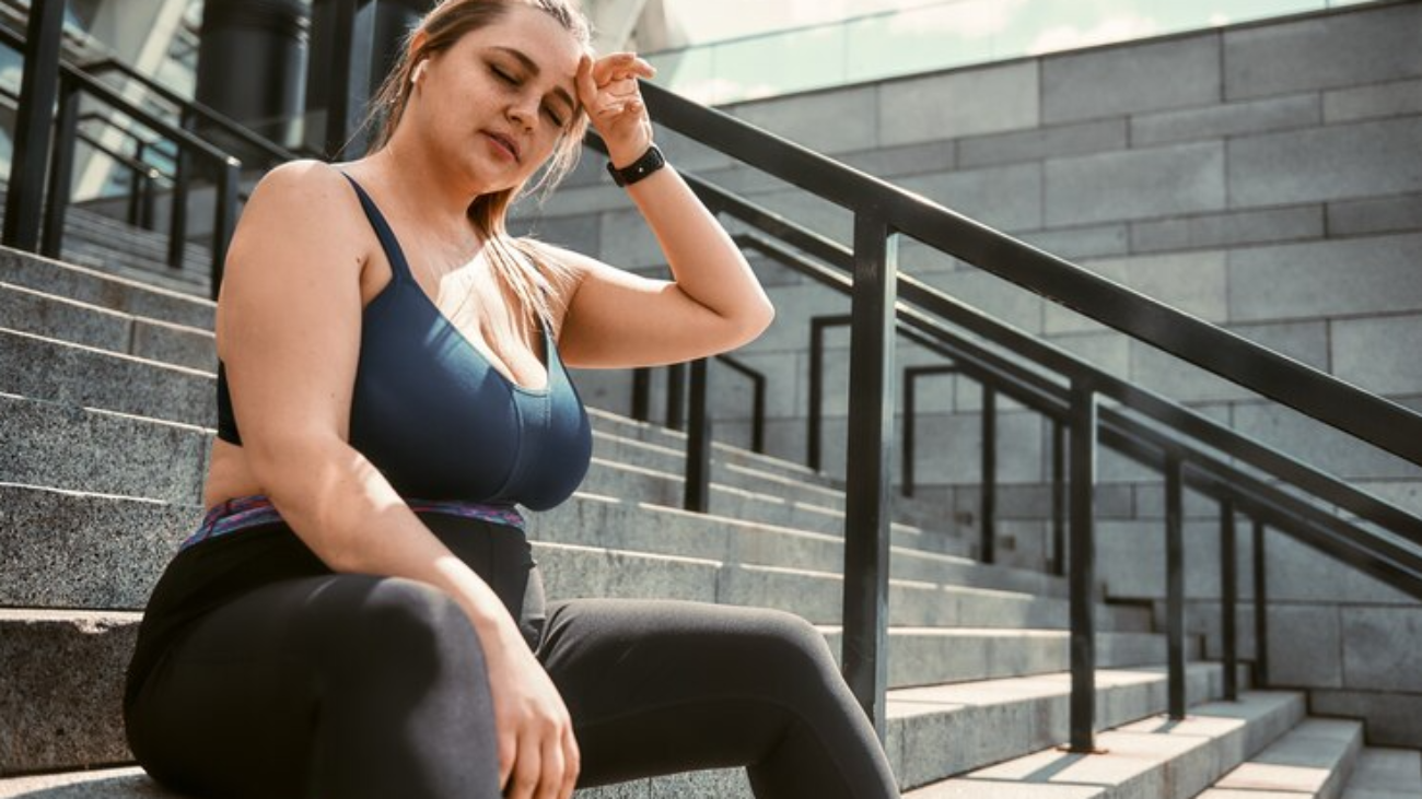 young-plus-size-woman-sports-clothing-keeping-eyes-closed-while-sitting-stairs-outdoors_386167-5104-jpg-740×494-