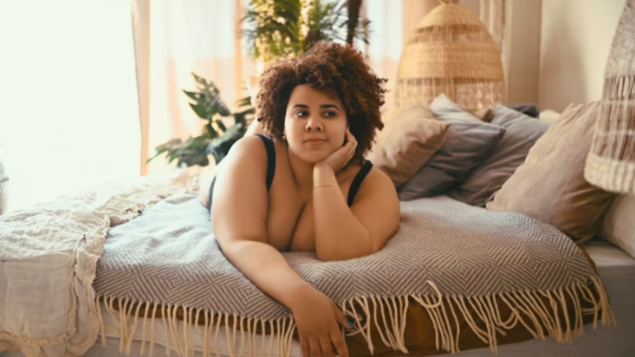 Premium-Photo-Beautiful-curvy-oversize-african-black-woman-afro-hair-lying-on-bed-eco-friendly-bedroom-cozy