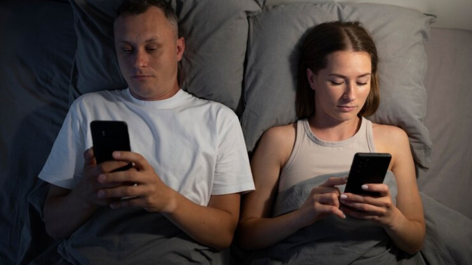 close-up-couple-phones-bedroom_23-2149070983