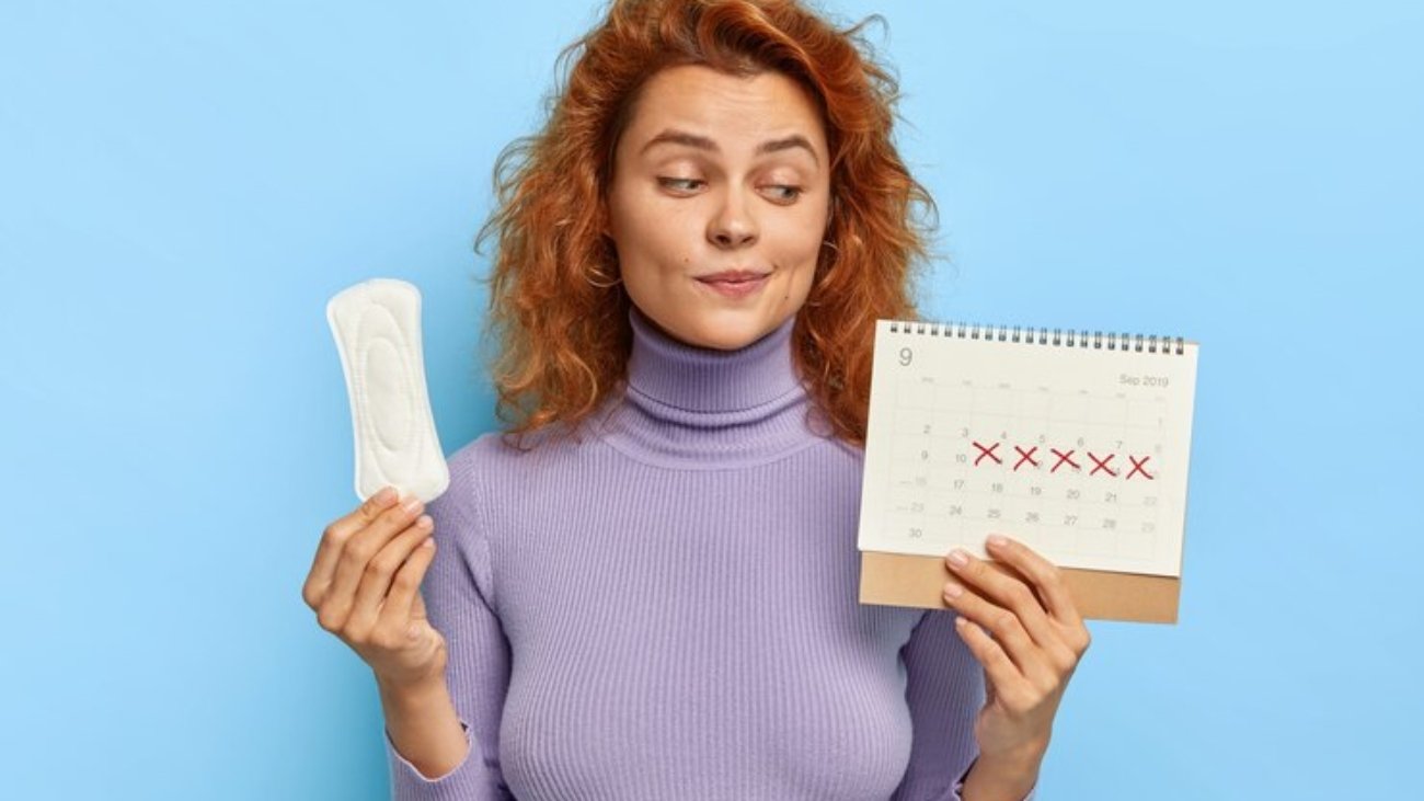 photo-young-woman-looks-period-calendar-checks-menstruation-days_273609-30253