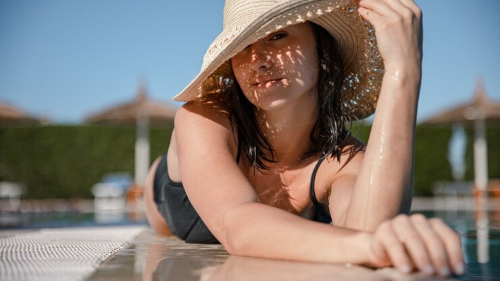 seductive-young-woman-relaxing-sun-near-pool-wearing-straw-hat-sunny-day-resort-summer-concept_169016-10843