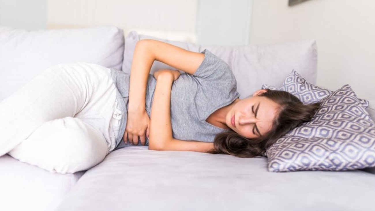 young-woman-haviing-abdominal-pain-because-menstruation-lying-couch-holding-her-stomach_231208-689