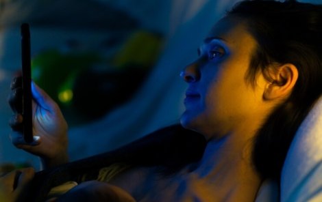 beautiful-mother-looking-smartphone-sitting-couch-night-with-his-baby-her-chest-reading_470418-252