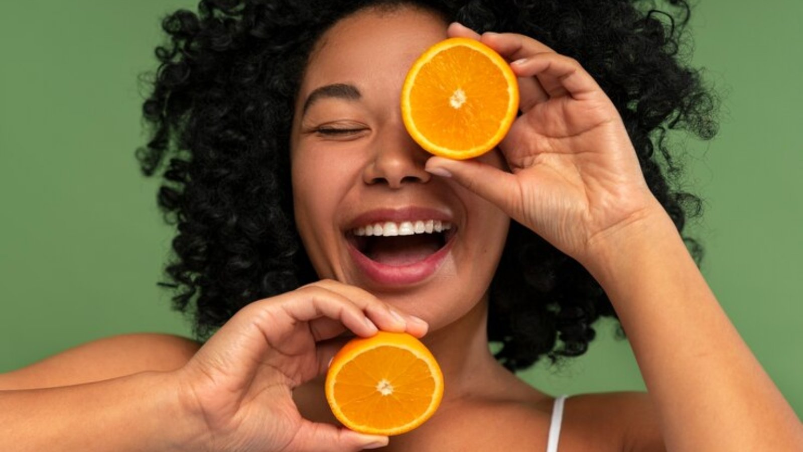 beautiful-woman-smiling-while-holding-oranges_52683-111882